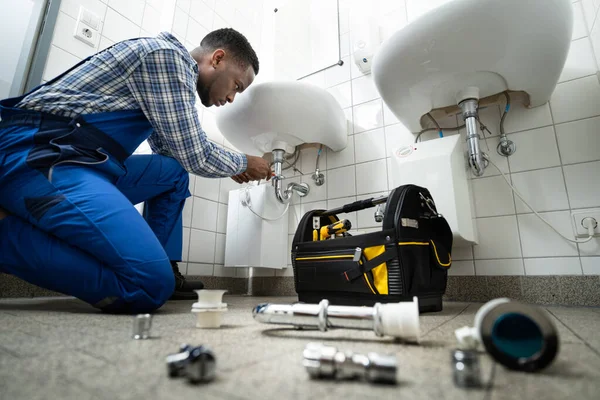 Lakewood plumber working under a sink